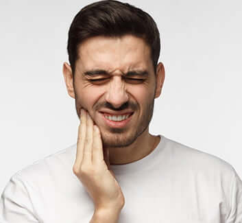 man holding his jaw in pain