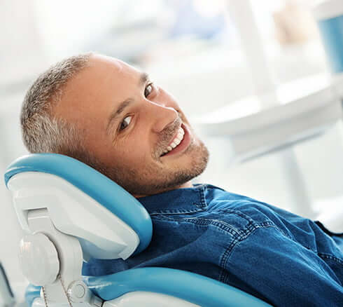 smiling man sitting in a dental chair