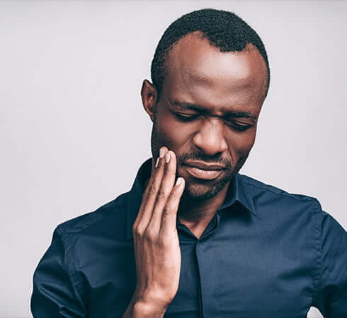 man holding his jaw in pain