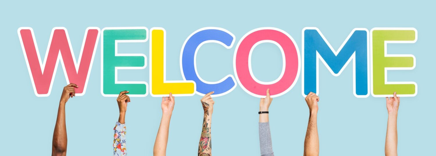 Hands holding the word welcome with multicolored letters