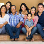 Multigenerational Latin family smiles with a child, teens, young adults, parents, and grandpa