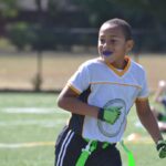 A boy playing flag football while wearing a sports mouthguard to protect his teeth