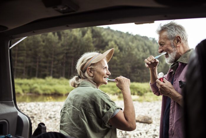 senior dental care, senior couple brushing their teeth while camping