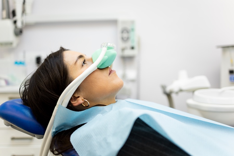 woman using nitrous oxide dental sedation at the dentist for dental anxiety